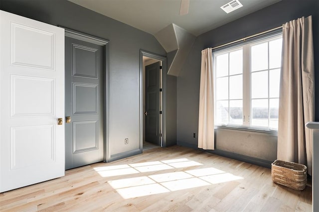 unfurnished bedroom with visible vents, baseboards, and wood finished floors