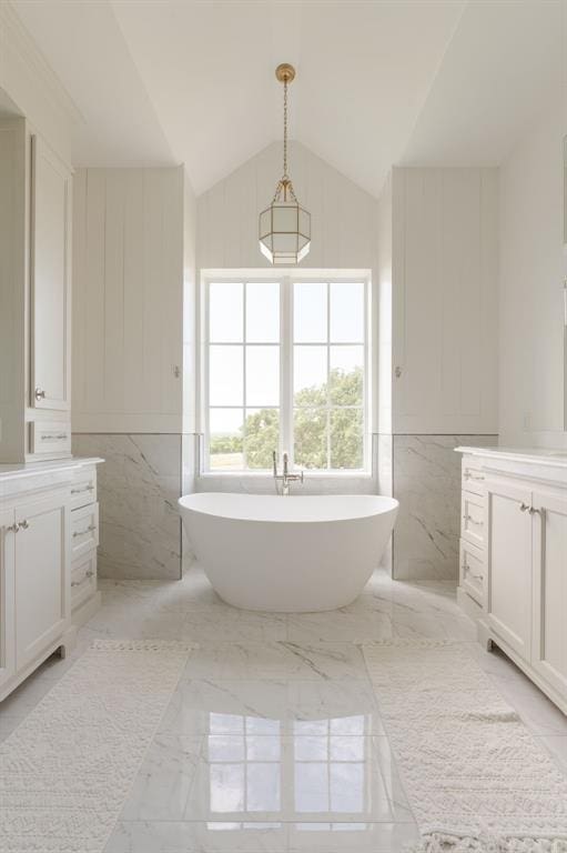 2909 High View Dr, Arcadia, OK 73007 - full bathroom featuring vanity, a soaking tub, marble tiled flooring, tile walls, and lofted ceiling