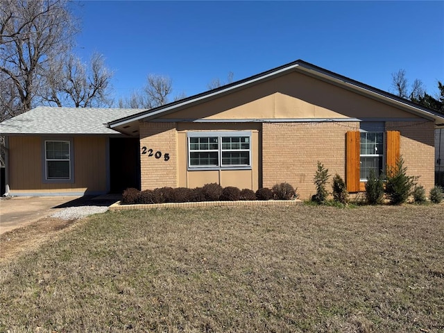 single story home featuring brick siding and a front yard