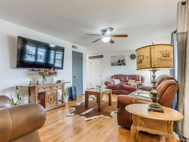 living area with light wood-style floors, visible vents, and a ceiling fan