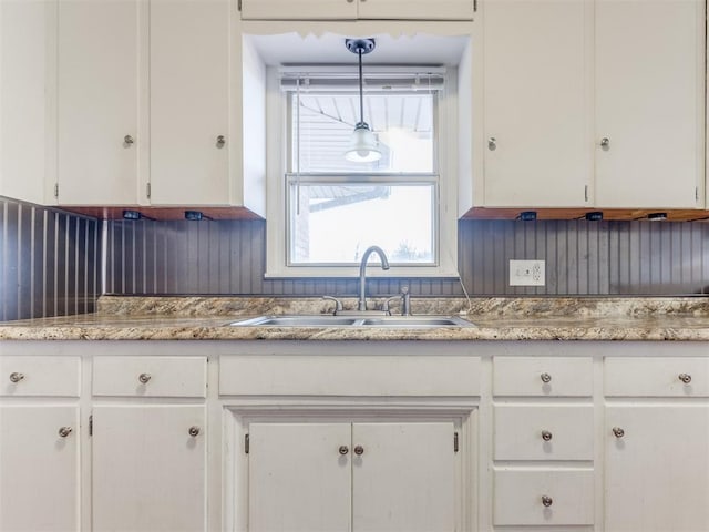 kitchen with a sink and white cabinetry