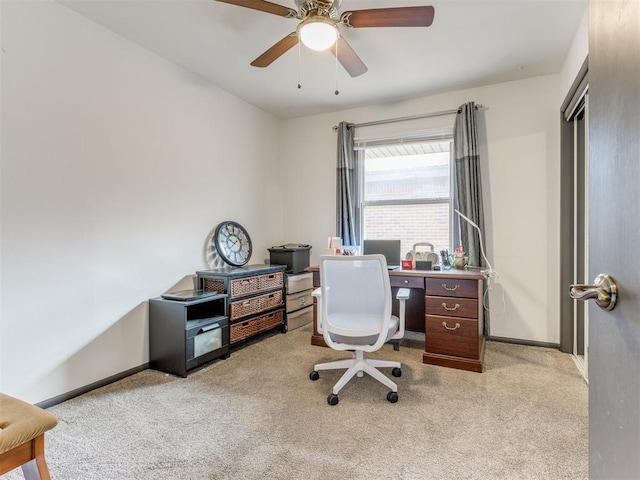 home office featuring a ceiling fan, light colored carpet, and baseboards