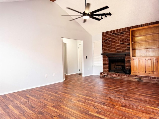 unfurnished living room featuring built in features, baseboards, ceiling fan, wood finished floors, and a brick fireplace