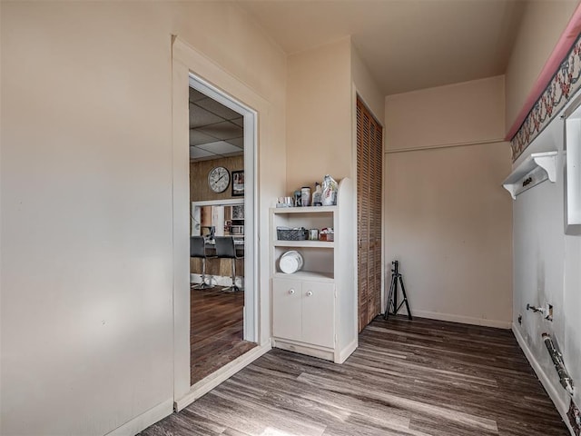 laundry area with baseboards and wood finished floors