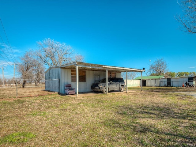 view of pole building with a yard, a carport, and fence