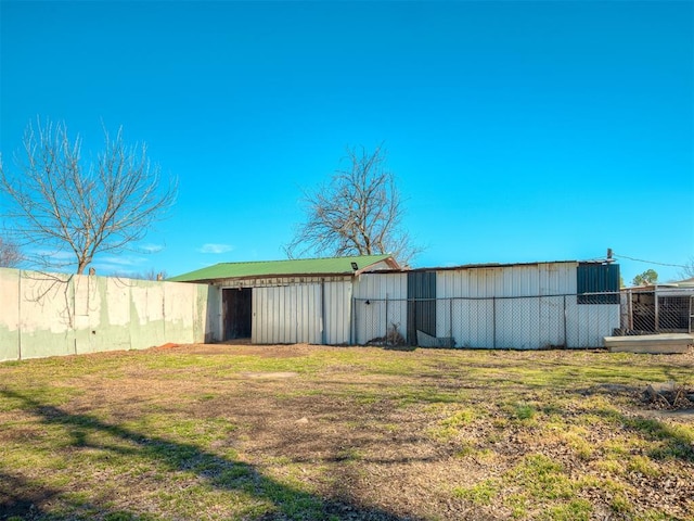 view of pole building featuring fence and a yard