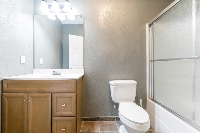 full bathroom with toilet, vanity, combined bath / shower with glass door, and a textured wall