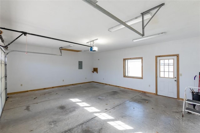 garage featuring electric panel, baseboards, and a garage door opener