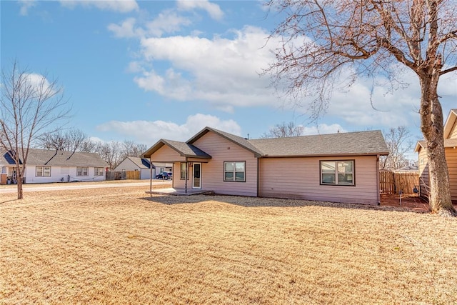 ranch-style house featuring a front yard and fence