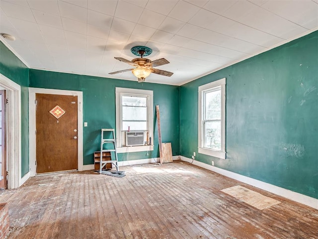 interior space featuring a ceiling fan, cooling unit, baseboards, and hardwood / wood-style flooring