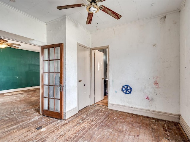 empty room featuring baseboards, a ceiling fan, hardwood / wood-style flooring, and crown molding