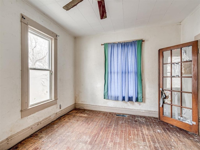 spare room with a wealth of natural light and hardwood / wood-style floors