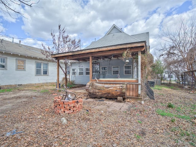 back of house with a fire pit and fence