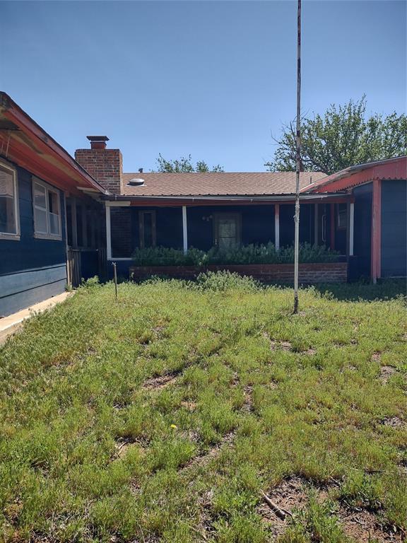 rear view of property with a lawn and a chimney
