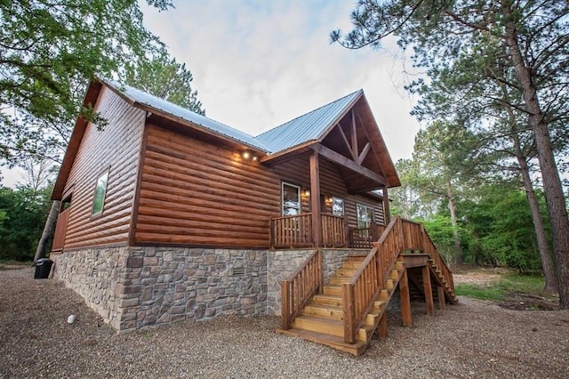 view of property exterior with stone siding, stairway, metal roof, and log veneer siding