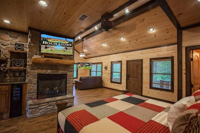 bedroom featuring a stone fireplace, wine cooler, wood finished floors, and wood ceiling