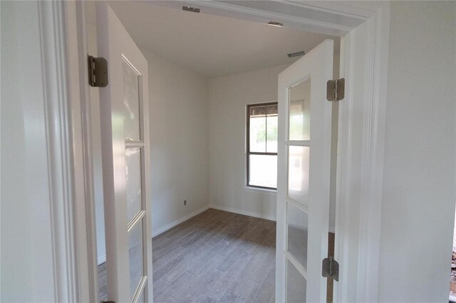 spare room featuring baseboards and wood finished floors
