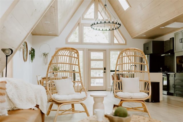 living area featuring a skylight, wood finished floors, wood ceiling, and an inviting chandelier