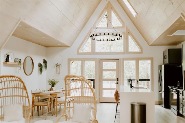 dining area featuring a chandelier, wooden ceiling, a skylight, and light wood-style floors