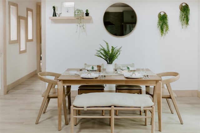 dining room featuring light wood-type flooring and baseboards