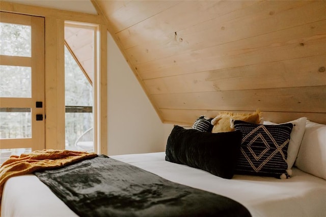 bedroom with lofted ceiling, wood ceiling, and multiple windows