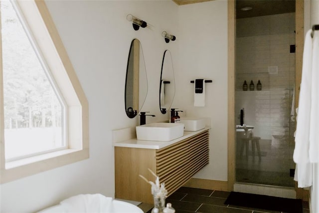 full bathroom with a sink, a shower stall, and double vanity