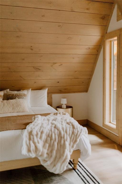 bedroom with lofted ceiling, wood ceiling, and baseboards