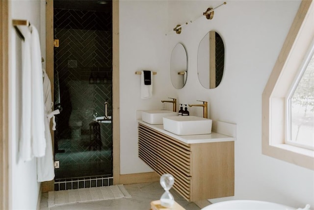 full bath featuring double vanity, a sink, and a shower stall