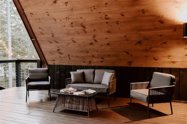 sitting room with expansive windows, wood walls, and hardwood / wood-style floors