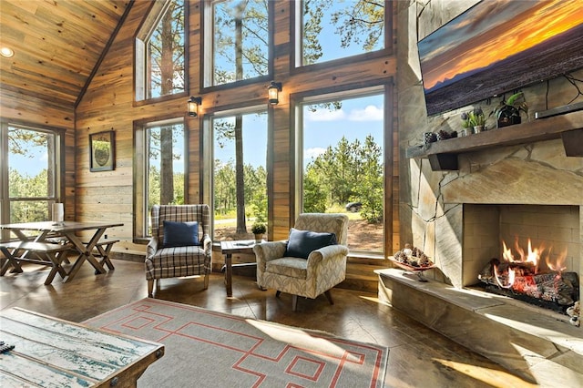 sunroom / solarium featuring lofted ceiling, wood ceiling, and a fireplace