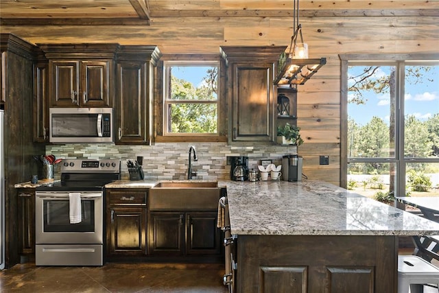 kitchen with dark brown cabinets, appliances with stainless steel finishes, backsplash, and a sink