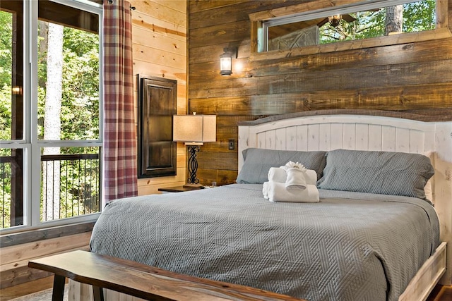 bedroom with multiple windows and wood walls