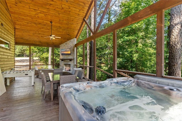 wooden terrace featuring ceiling fan, an outdoor living space with a fireplace, and a hot tub