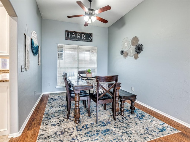 dining space with ceiling fan, wood finished floors, and baseboards