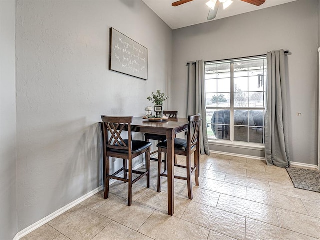 dining space with ceiling fan and baseboards