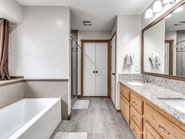 bathroom featuring a garden tub, a shower stall, a sink, and wood finished floors