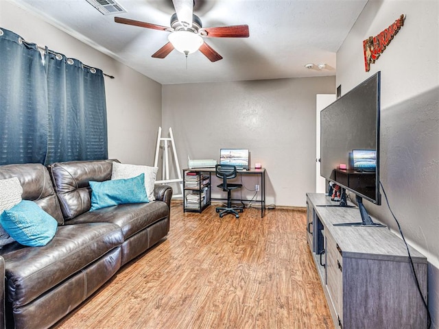 office featuring ceiling fan, baseboards, visible vents, and light wood-style floors