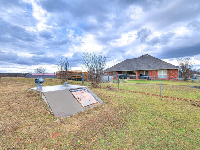 entry to storm shelter with a lawn and fence