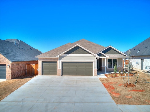 craftsman-style home featuring driveway, a shingled roof, an attached garage, fence, and brick siding