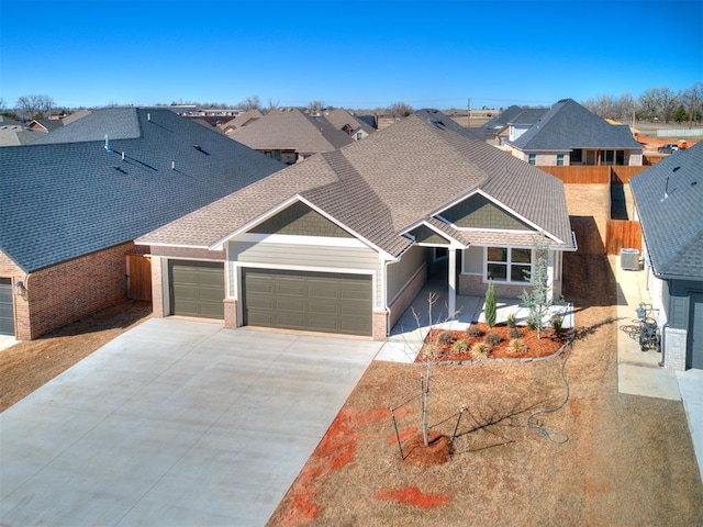 view of front of home featuring a garage, roof with shingles, driveway, and fence