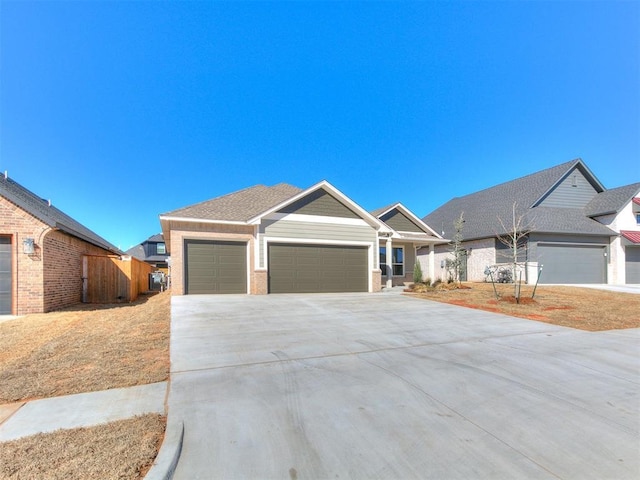 view of front of property featuring a garage, a shingled roof, brick siding, fence, and driveway