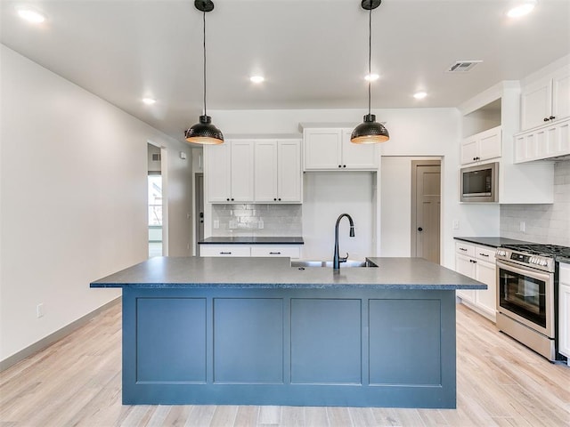 kitchen featuring stainless steel gas stove, dark countertops, a sink, and built in microwave