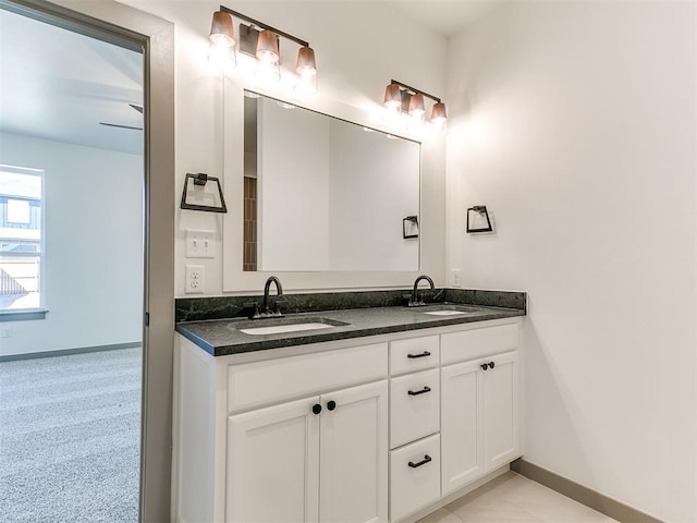 full bath with a sink, baseboards, and double vanity