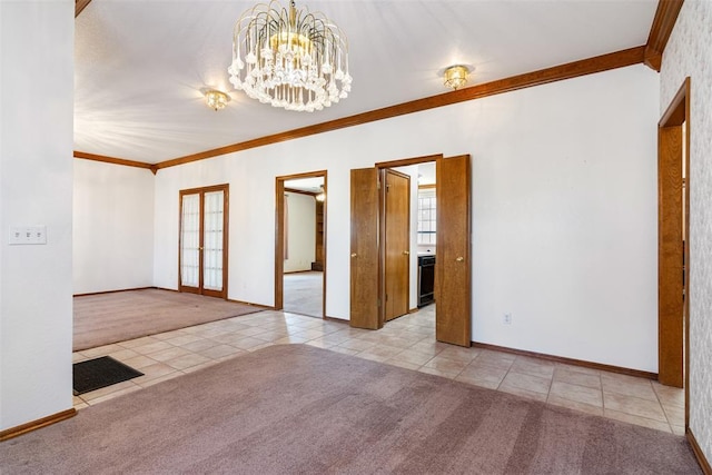 carpeted empty room featuring baseboards, ornamental molding, tile patterned floors, french doors, and a notable chandelier