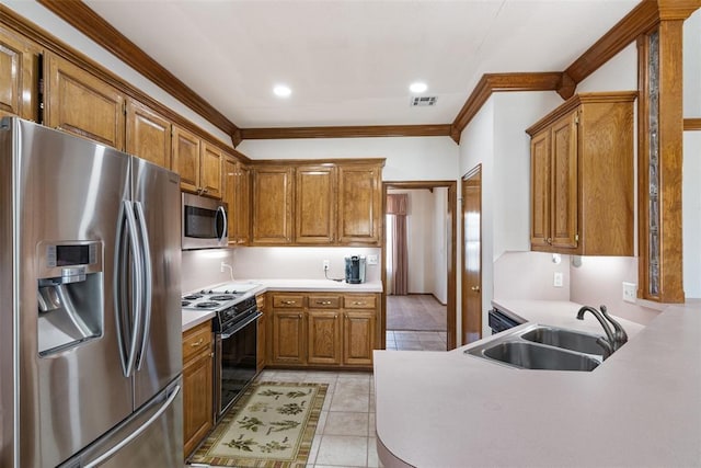 kitchen with stainless steel appliances, a sink, light countertops, and brown cabinets