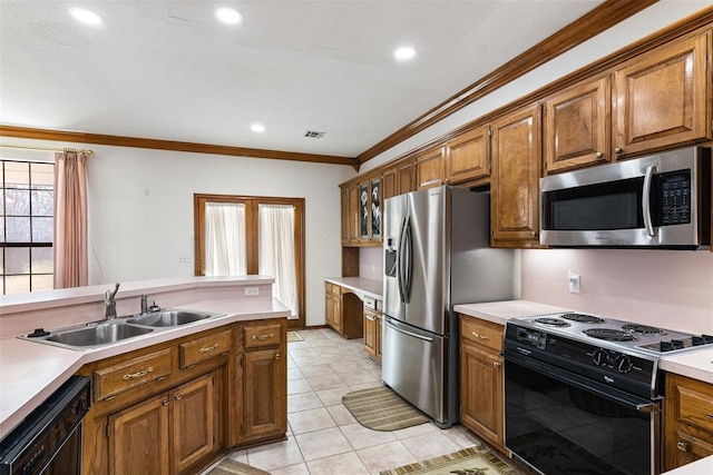 kitchen featuring black appliances, ornamental molding, brown cabinets, and a sink