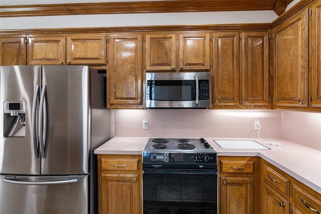 kitchen featuring light countertops, appliances with stainless steel finishes, and brown cabinetry