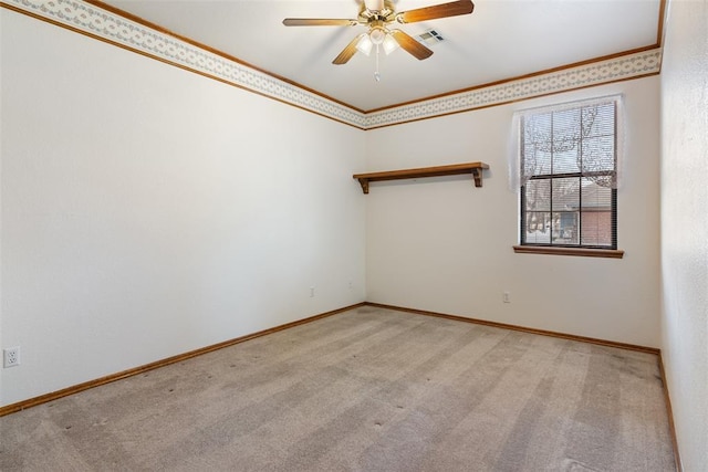 empty room featuring light carpet, baseboards, ornamental molding, and a ceiling fan