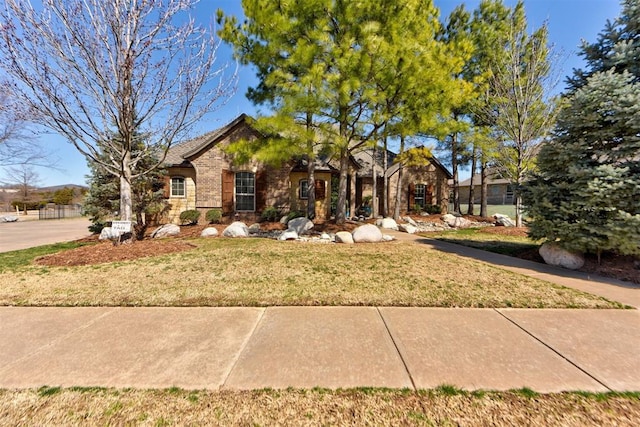 view of front of home with stone siding, a front lawn, and brick siding