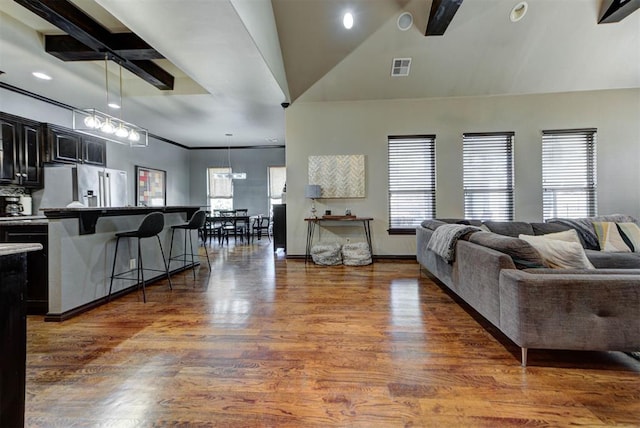 living area with visible vents and wood finished floors